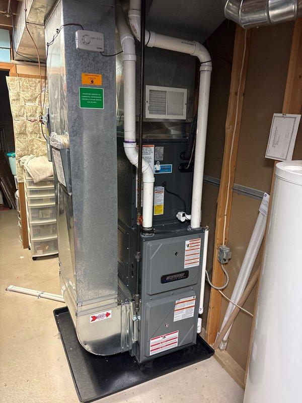 Successfully installed new furnace and air conditioning system in residential basement. Complete installation included proper mounting of furnace on protective pad, connection of all necessary PVC venting/drain lines, and verification of copper line connections. System was tested and confirmed operational with all safety labels and documentation properly affixed.