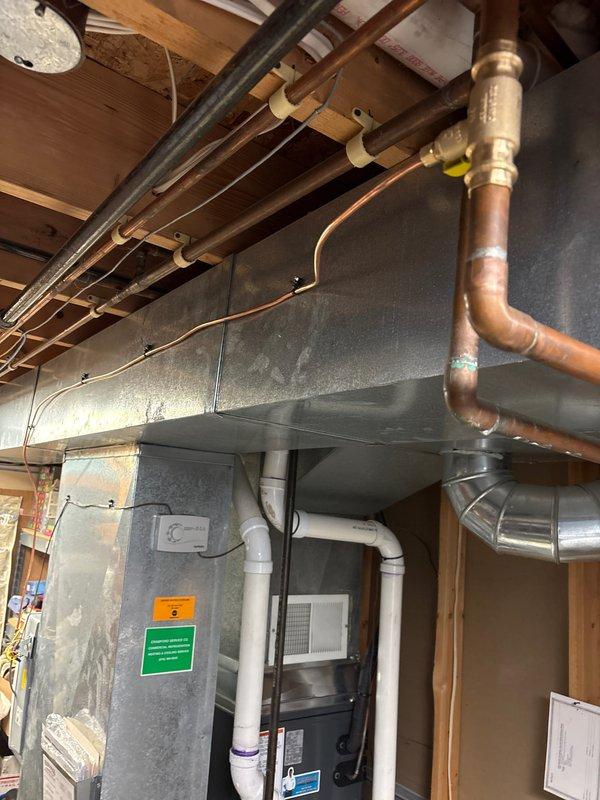 Successfully installed new furnace and air conditioning system in residential basement. Complete installation included proper mounting of furnace on protective pad, connection of all necessary PVC venting/drain lines, and verification of copper line connections. System was tested and confirmed operational with all safety labels and documentation properly affixed.