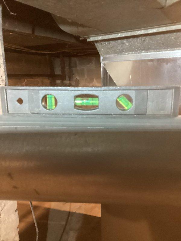 Completed CORR inspection correction on newly installed Carrier furnace (CM: 2026). Verified proper venting alignment and pitch of flue pipe using spirit level, ensuring exhaust gases flow correctly. System is operating properly and now complies with inspection requirements.