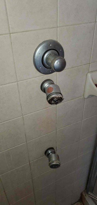 Inspected shower control system in master bath where overhead and body jets were non-operational. Discovered significant mineral buildup and wear on the shower valve assembly and diverter controls. Cleaned calcium deposits from valve components and adjusted water flow regulators to restore proper function to all jets.