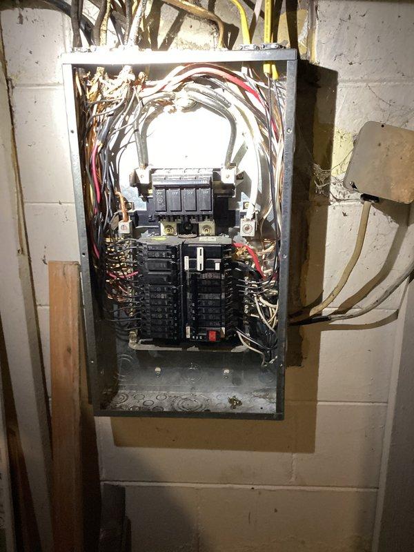 Performed ECI inspection of electrical panel and water heater installation. Panel inspection revealed multiple circuit breakers with somewhat disorganized wiring, including various colored conductors entering from the top. Water heater examination showed proper installation with appropriate ventilation ductwork and copper supply lines connected to the Smith unit.