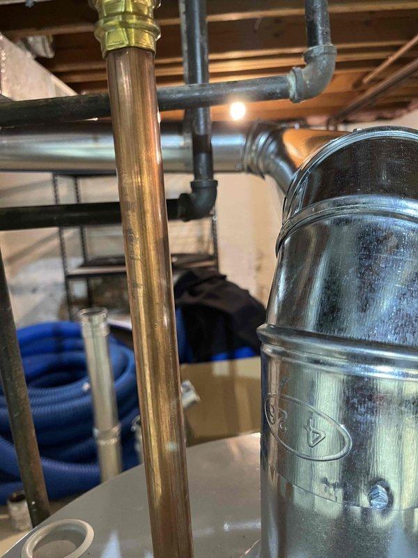 Corrected B-vent connector from water heater to existing chimney liner that was installed backwards, as indicated by flow direction arrow stamped on B-vent. Replaced improper single wall vent connection that was incorrectly screwed to male end of Hart and Cooley B-vent with manufacturer-approved listed chimney liner to B-vent connector per code requirements.