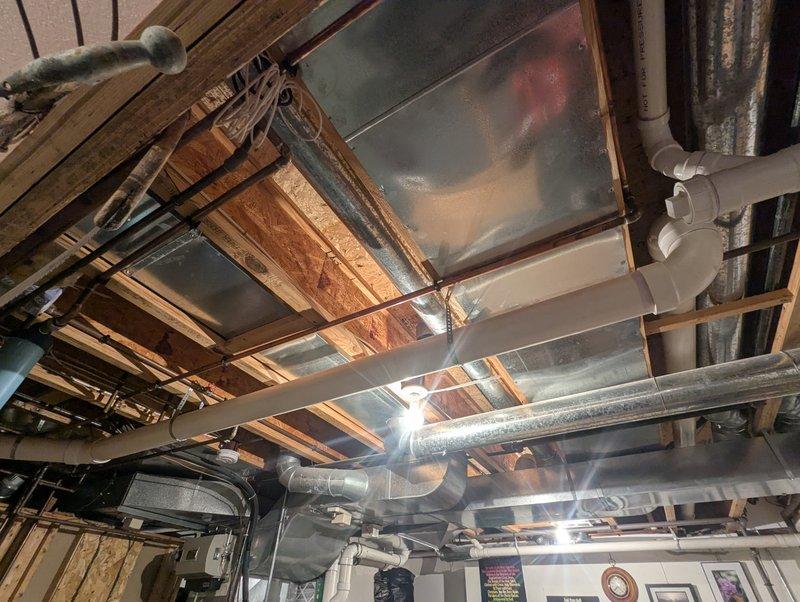 Completed estimate for 75-gallon AO Smith water heater replacement. Inspected existing plumbing infrastructure including PVC drainage/venting system and copper supply lines. Evaluated ceiling area with exposed joists, HVAC ductwork, and utility connections to ensure proper installation requirements for the new unit.