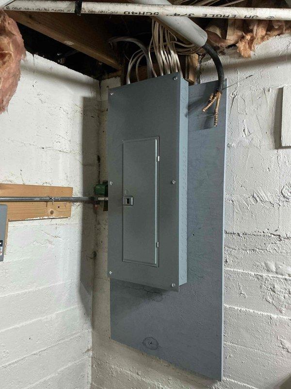 Completed 100A Electric Service Upgrade on a residential property under permit #PE26-010, coordinating with utility company for power disconnect/reconnect. Installation included a new panel mounted on the concrete block wall in the basement utility area, with proper routing of electrical cables through ceiling joists. Inspection was successfully completed by county inspector.