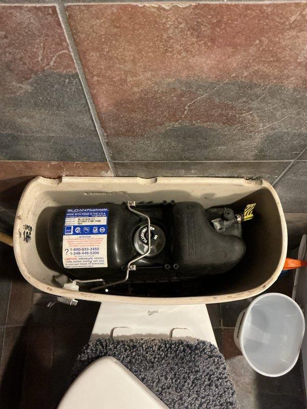 Diagnosed repeat toilet malfunction in downstairs bathroom that was previously serviced 1-1.5 months ago. Inspected internal tank components and found mineral buildup affecting the flush valve assembly. Cleaned mineral deposits, adjusted float mechanism, and verified proper water supply connection at base to restore proper functionality under warranty service.