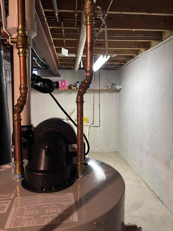 Responded to service call for leaking fitting on water heater. Inspected copper supply pipes and identified significant corrosion and active leak at connection point. Replaced damaged section of pipe and fitting, ensuring proper seal and connection integrity. System now functioning properly with no signs of leakage.