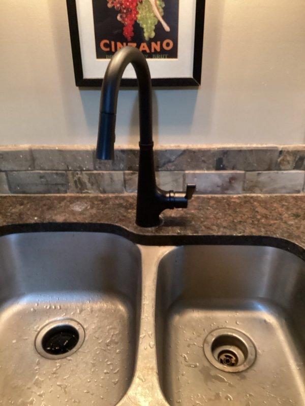 Replaced leaking basement kitchen faucet with new customer-supplied black model featuring high arching neck design. Installed all necessary supply lines and verified proper function with no leaks at connections.