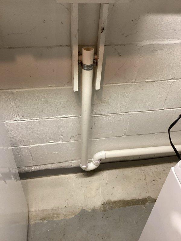 Successfully installed a dedicated laundry standpipe by connecting to the existing utility sink drain using a sanitary tee fitting. Properly secured vertical PVC drain pipe to wall with mounting brackets and configured appropriate P-trap assembly to ensure proper drainage and venting per code requirements.
