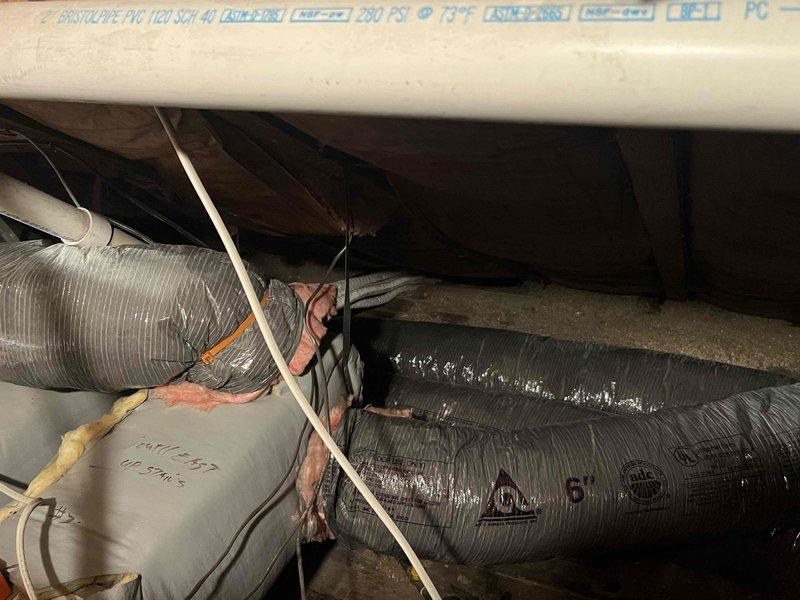 Performed diagnostic assessment on 9-year-old mini-split system in Room 2 that has required multiple refrigerant charges. Inspection of crawl space revealed deteriorated ductwork insulation and compromised connections at several junction points. Determined system's slow heating/cooling performance is due to significant refrigerant leak requiring comprehensive repair rather than continued recharging.