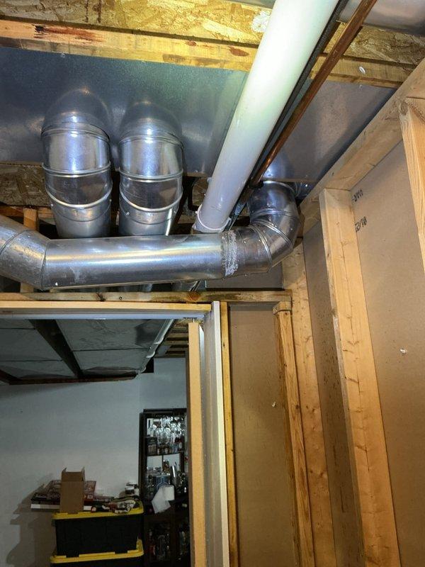 Responded to service call for tub leak. Inspection revealed condensation on metal HVAC ductwork in basement area, with visible water droplets forming on the main duct surface. Confirmed proper placement of plumbing components and resolved the moisture issue.