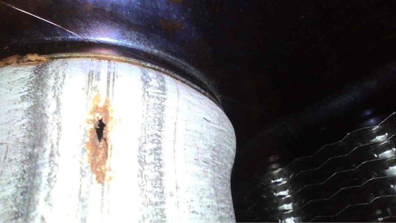 Performed annual tune-up on 10-year-old Goodman furnace. Inspection revealed significant corrosion and perforation in the heat exchanger, including a hole with surrounding rust damage. Documented evidence of metal deterioration with photos for customer records.