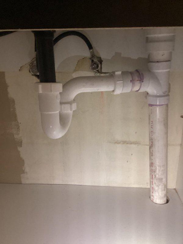 Returned to site as quoted to rebuild plumbing stack and install new vent. Accessed wall cavity through existing opening, revealing PVC drainage system. Completed installation of P-trap assembly under sink with proper connections to vertical drain pipe and flexible connector to basin. CWOW.