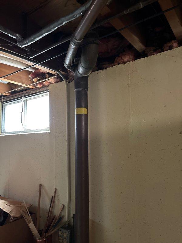 Responded to slow leak in 64-year-old home's bathroom sink present for approximately 3 days. Inspection revealed significant water damage to the cabinet and wall surrounding the drain assembly, with extensive deterioration of particleboard and drywall. Replaced damaged P-trap assembly and drain components, ensuring proper seals and connections to resolve the leak.