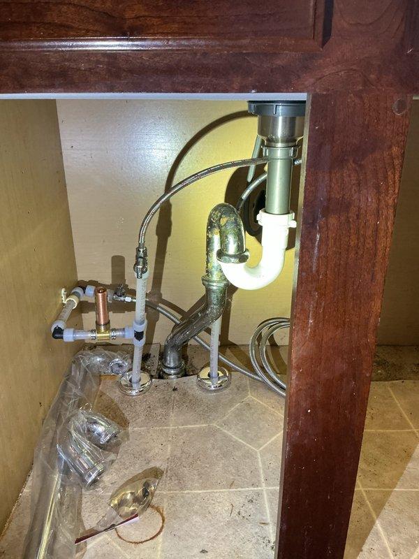 Cleared kitchen sink drain line obstruction that was causing slow drainage in 100-year-old home. Inspected under-sink P-trap assembly and verified proper function. Traced drainage issue to main waste line and cleared blockage, restoring normal drainage flow.