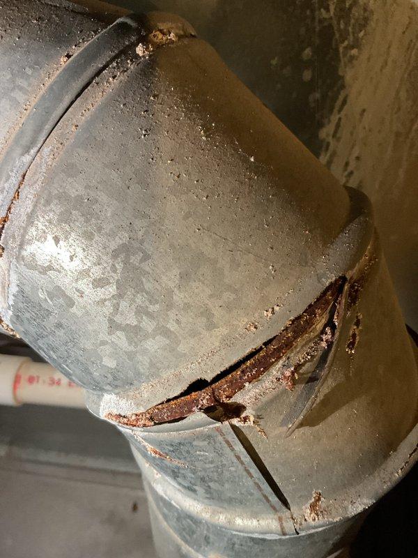 Performed scheduled annual heating tune-up on furnace system (no humidifier present). During inspection, discovered significant corrosion and deterioration on metal ductwork, including a visible crack in the pipe connection with moisture present. Documented damage with photos for reference. System otherwise functioning normally at time of service.