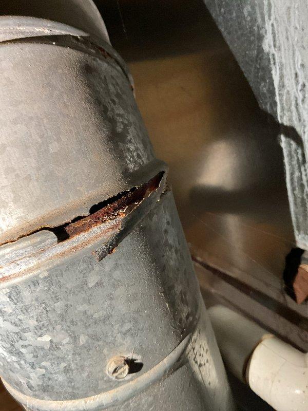 Performed scheduled annual heating tune-up on furnace system (no humidifier present). During inspection, discovered significant corrosion and deterioration on metal ductwork, including a visible crack in the pipe connection with moisture present. Documented damage with photos for reference. System otherwise functioning normally at time of service.