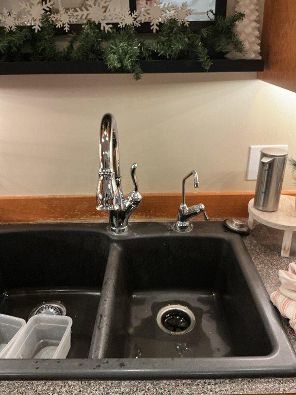 Diagnosed and repaired a slow leak originating from the main kitchen faucet, which was initially thought to be coming from the adjacent reverse osmosis system. Inspected under-sink plumbing components, including PVC drain pipes and supply lines, and found no issues with the RO system connections. Completed necessary repairs to resolve the leak at the faucet assembly.