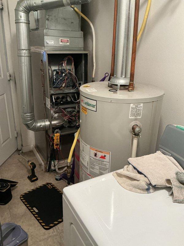 Performed annual tune-up on Carrier furnace (Model WT 11-2028, manufactured 2021) with no humidifier. Inspected all internal components including electrical connections, circuit board, and mechanical elements. System is functioning properly with no issues identified. Documented service with photos of the complete HVAC installation including furnace and adjacent water heater.