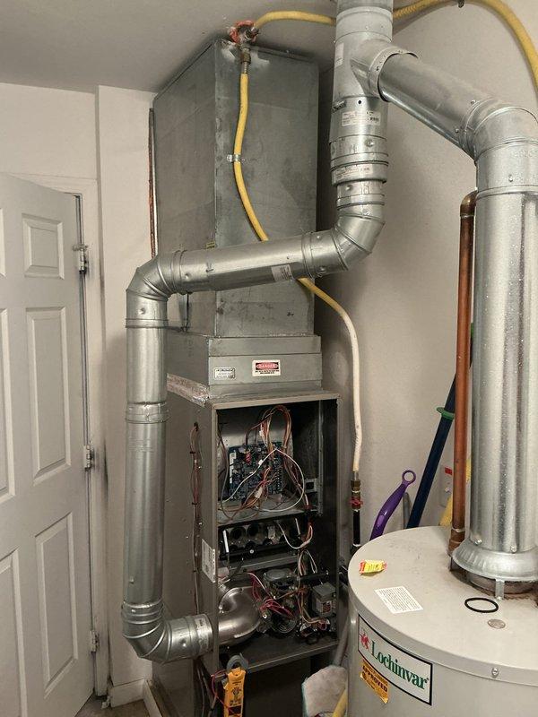 Performed annual tune-up on Carrier furnace (Model WT 11-2028, manufactured 2021) with no humidifier. Inspected all internal components including electrical connections, circuit board, and mechanical elements. System is functioning properly with no issues identified. Documented service with photos of the complete HVAC installation including furnace and adjacent water heater.