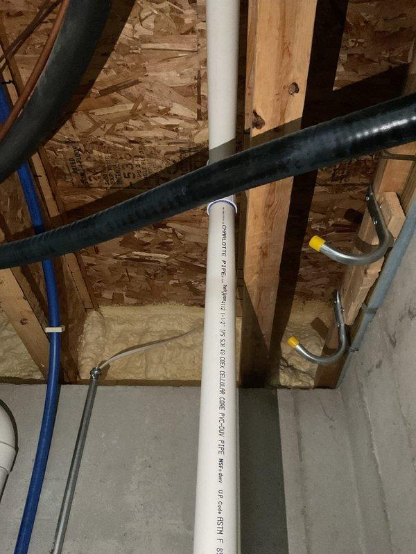 Conducted inspection of sump pump system in 8-year-old condo following home inspection concerns. Examined existing check valve installation and drainage configuration in basement utility area, documenting current condition with photos of the sump pit installation and associated plumbing infrastructure. Recommended possible replacement of LVM/Sample pump pending further assessment.