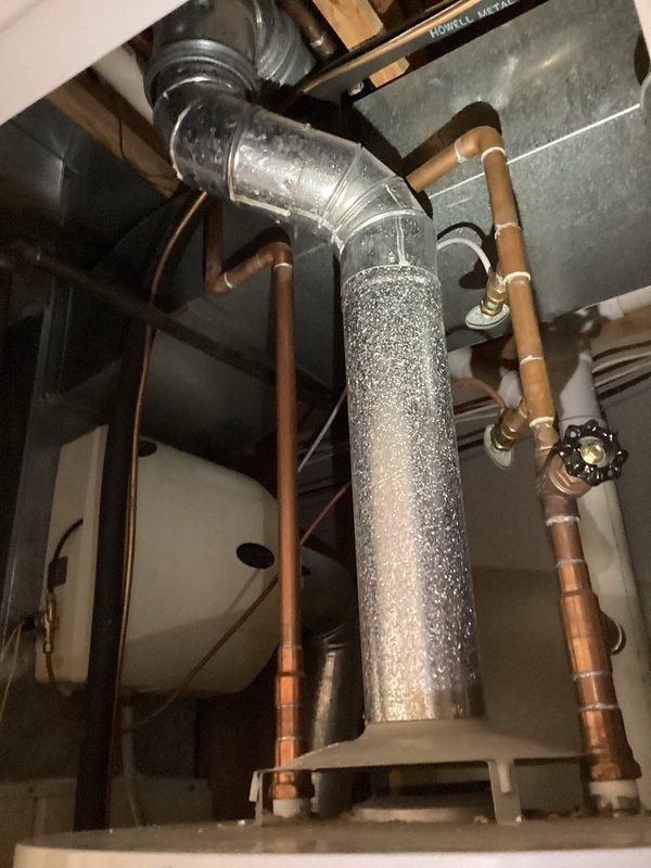 Performed inspection of 24-year-old water heater requiring replacement, located in confined utility space. Documented existing installation with photographs showing copper supply lines, ventilation, and current unit positioning. Provided customer with replacement options and information on Comfort Club membership, noting their plans for future HVAC system replacement.