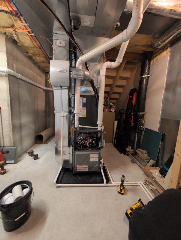 Performed complete installation of new furnace and air conditioning system. New AC condenser was properly installed on gravel bed with concrete paver retaining wall for stability. Indoor furnace unit was installed in basement with appropriate PVC ventilation system and all necessary electrical connections completed.