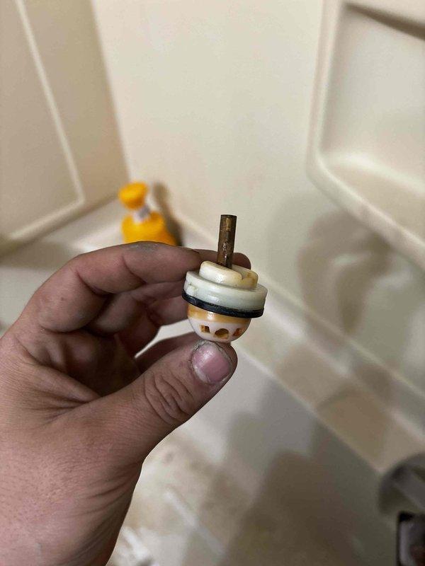 Responded to a service call for water leakage from a second-floor bathroom causing ceiling damage and staining around a recessed light fixture below. Upon inspection, identified a deteriorated faucet cartridge with mineral buildup and damaged seals as the source of the leak. Removed and replaced the faulty cartridge to resolve the issue.