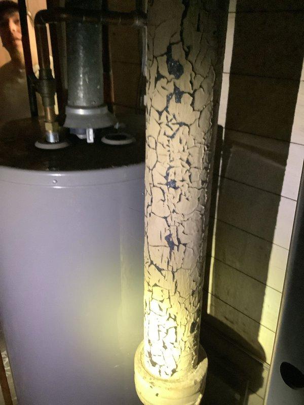 Conducted a site assessment for installation of new bathroom and laundry facilities on the main floor, documenting a floor access point with exposed soil/gravel substrate and an existing water heater with severely deteriorated adjacent piping showing extensive alligator cracking and outer coating failure. Coordinated with comfort advisor regarding mini-split or alternative heat source options for the space.