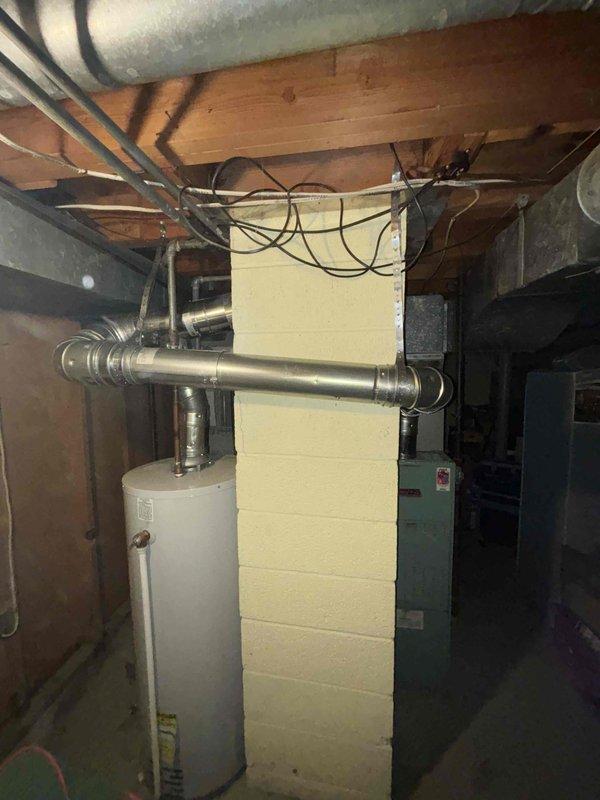 Conducted comprehensive inspection of basement mechanical room housing water heater and HVAC system. Examined ducting, plumbing connections, and electrical wiring for proper installation and potential issues. Documented condition of equipment with photos showing normal operating state with no visible damage, rust, or leakage.