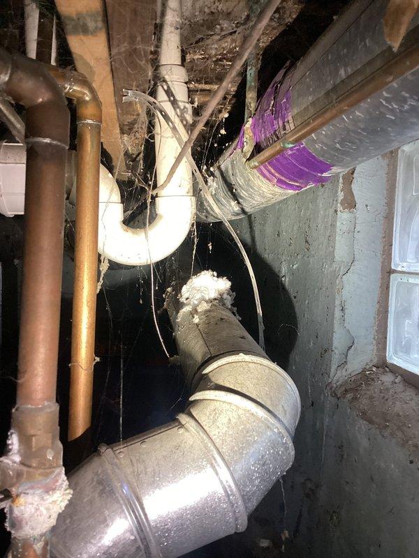 Conducted an estimate for water heater replacement options, including both tankless and traditional tank models. Existing unit shows significant corrosion and rust on top surface with compromised connections. Installation environment includes limited access in utility area with exposed plumbing, ductwork, and block glass window, requiring careful consideration for replacement logistics.