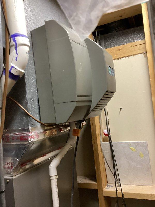 Performed annual furnace tune-up as part of Comfort Club membership on 8-year-old Lennox system. Inspected ceiling-mounted HVAC components and ductwork, noting all connections properly sealed with foil tape. Examined humidifier mounted on ductwork with PVC connection; system appears to be functioning properly with no issues identified.