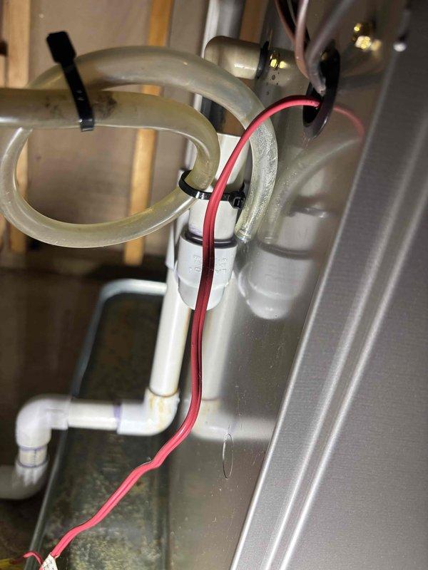 Responded to water leak service call for 9-year-old Bryant system. Inspected basement area showing water damage and staining on concrete walls. Examination of plumbing components revealed leakage from deteriorated plastic tubing connections under the fixture, which were replaced and secured with proper mounting clips to prevent future leakage.