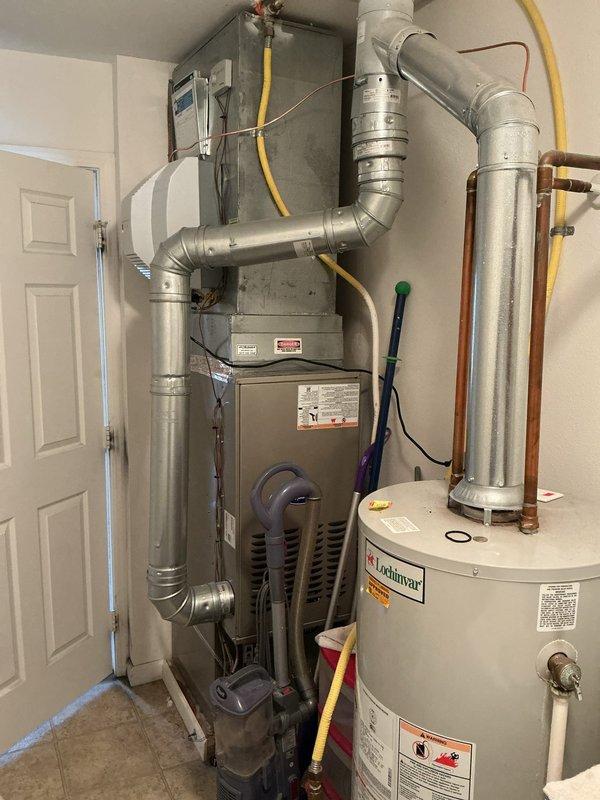 Successfully installed a powered humidifier system connected to the existing HVAC setup, including proper copper pipe installation with a T-junction and control valve. The humidifier was mounted securely and connected to the ductwork with all necessary plumbing components properly secured and tested for operation.