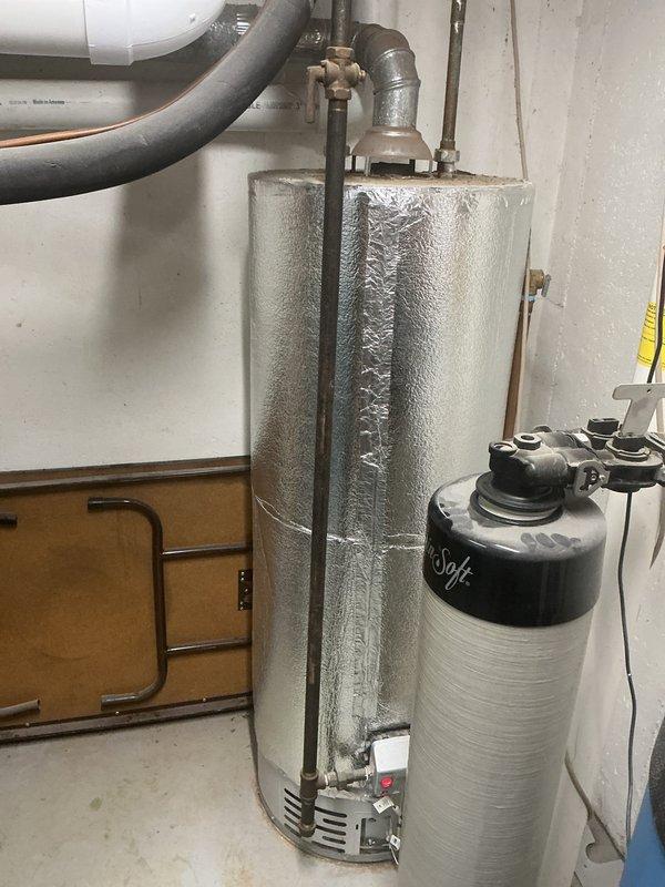 Investigated odor complaint from water heater in furnace room. Inspected 5-year-old furnace system, water heater connections, and associated plumbing components including brass valve assembly. System was found to be operating normally with no gas leaks detected; recommended routine maintenance to prevent future issues.