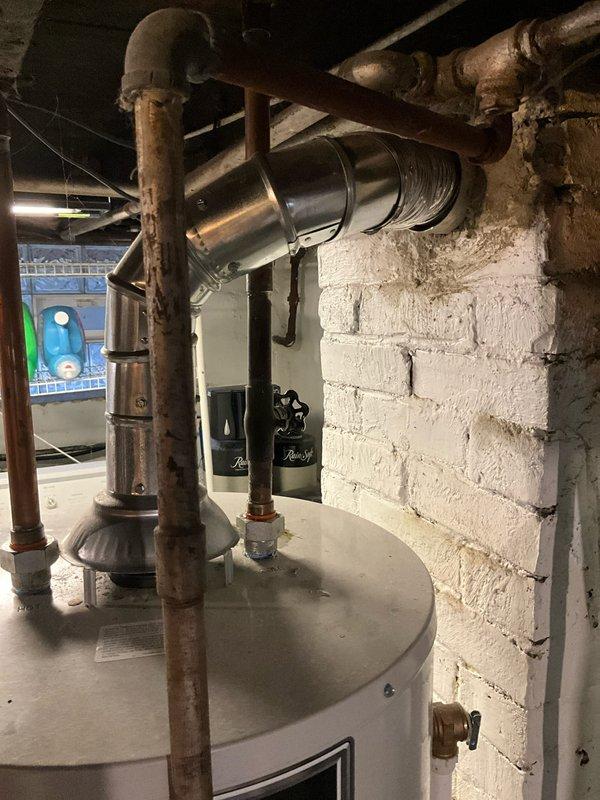 Responded to service call for 9-year-old leaking water heater in basement utility area. Inspection revealed corrosion at pipe connections and tank seam, indicating end-of-life failure. Recommended complete unit replacement due to age and extent of water damage.