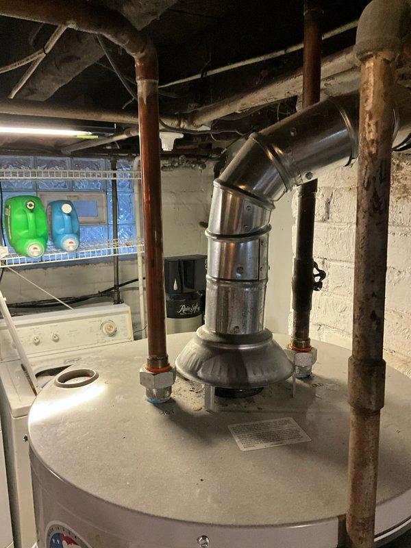 Responded to service call for 9-year-old leaking water heater in basement utility area. Inspection revealed corrosion at pipe connections and tank seam, indicating end-of-life failure. Recommended complete unit replacement due to age and extent of water damage.