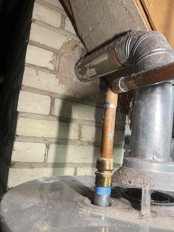 Conducted a water heater inspection on a 9-year-old Rheem unit that was actively leaking from the bottom. Documentation included photos of the existing plumbing setup, showing copper supply lines with brass fittings, galvanized vent piping, and the current installation configuration against brick wall in utility area. Provided customer with replacement options.