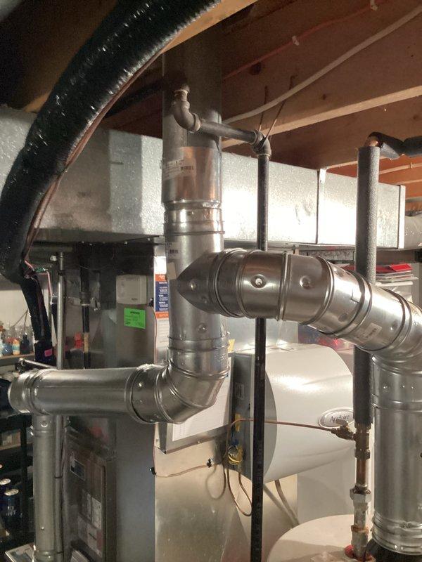 Diagnosed 12-year-old water heater that was not producing hot water; found faulty thermocouple and replaced it, restoring proper ignition and heating functionality. Verified proper venting of exhaust gases through the existing metal ductwork system and confirmed unit was operating within manufacturer specifications after repair.