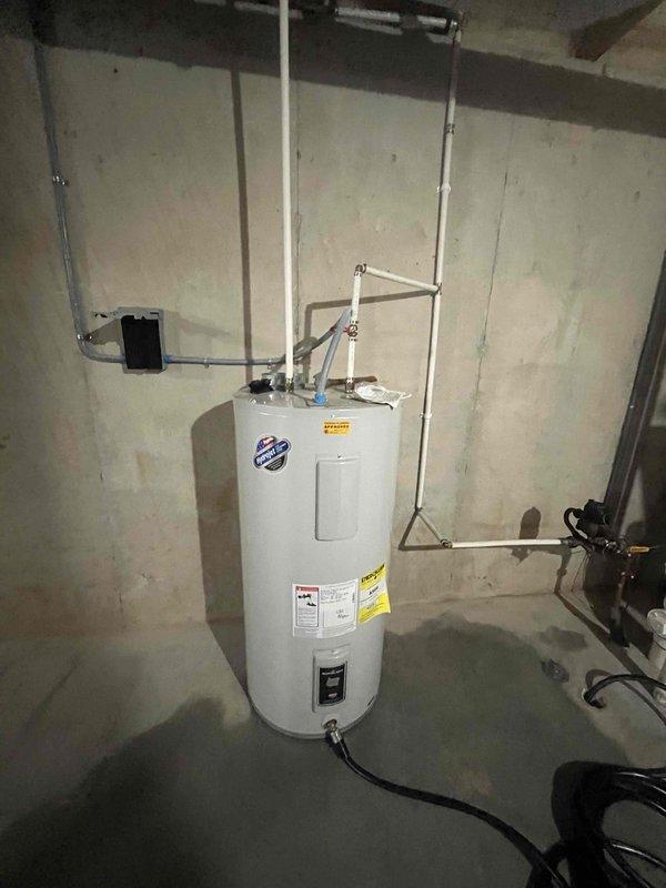 Conducted comprehensive water heater replacement estimate for CWOW, documenting existing installation located in unfinished basement. Photographed current unit showing standard cylindrical tank with PVC venting system, multiple pipe connections, and electrical components to provide accurate assessment for potential replacement options.