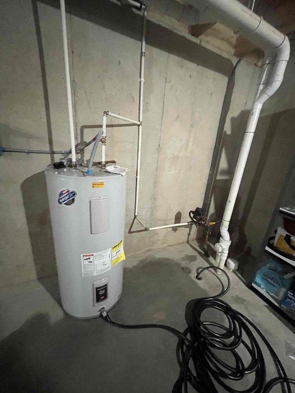 Conducted comprehensive water heater replacement estimate for CWOW, documenting existing installation located in unfinished basement. Photographed current unit showing standard cylindrical tank with PVC venting system, multiple pipe connections, and electrical components to provide accurate assessment for potential replacement options.