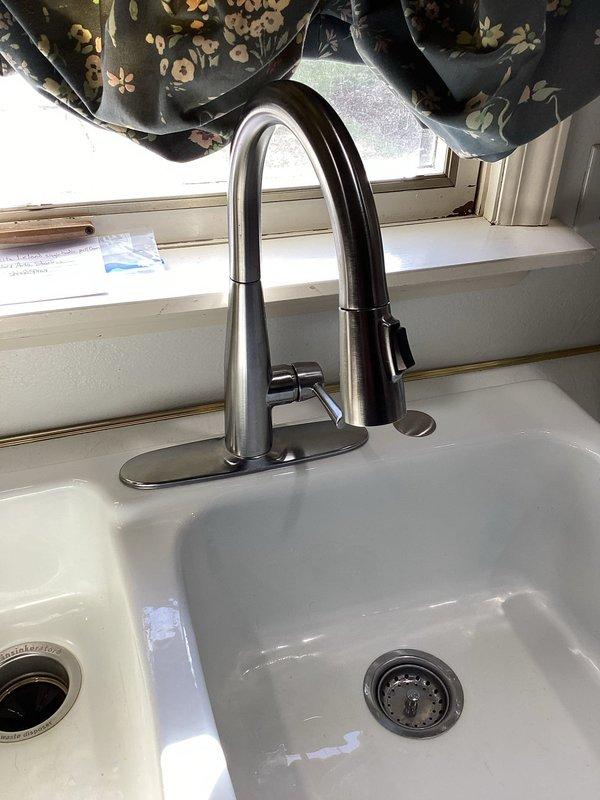 Installed new kitchen faucet in a 50-year-old home, replacing an existing unit that had been problematic for approximately one month. Successfully completed installation of the modern pull-down stainless steel faucet with single lever handle, ensuring proper functionality and no leaks.