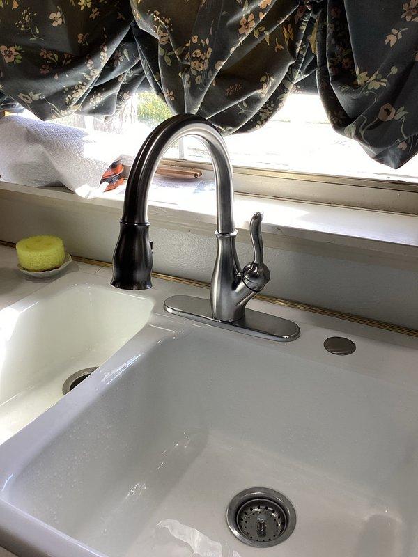 Installed new kitchen faucet in a 50-year-old home, replacing an existing unit that had been problematic for approximately one month. Successfully completed installation of the modern pull-down stainless steel faucet with single lever handle, ensuring proper functionality and no leaks.