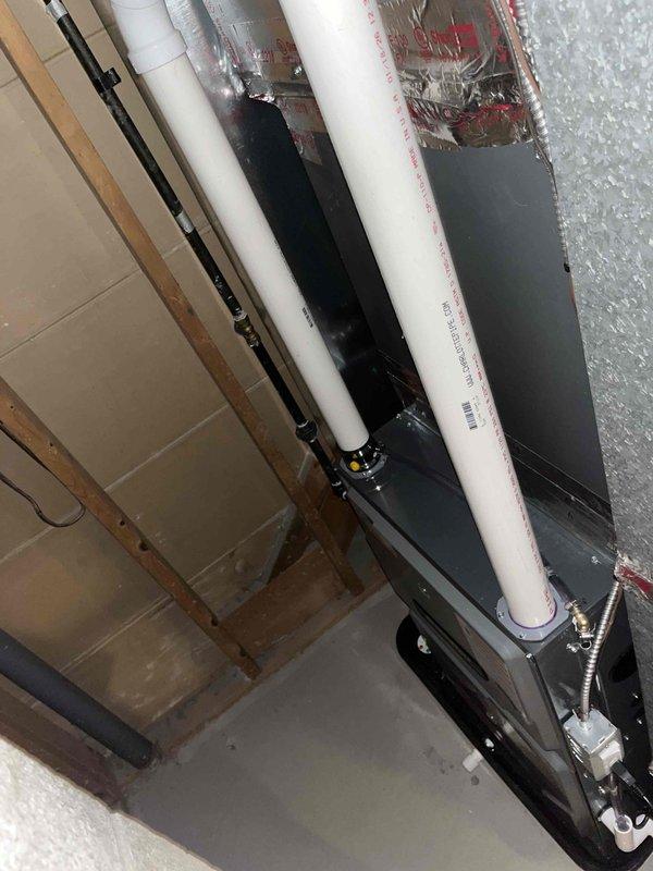 Successfully completed installation of new energy-efficient furnace with dual PVC ventilation system. Unit was properly mounted on concrete floor in utility space with all necessary connections to existing plumbing and mechanical systems. System was tested and confirmed operational as evidenced by active indicator lights.