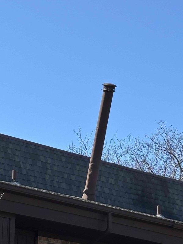 Completed annual maintenance on 11-year-old York furnace under home warranty service. Inspected and verified proper venting system, noting the angled metal chimney pipe installation is functioning correctly. No humidifier present in the system.