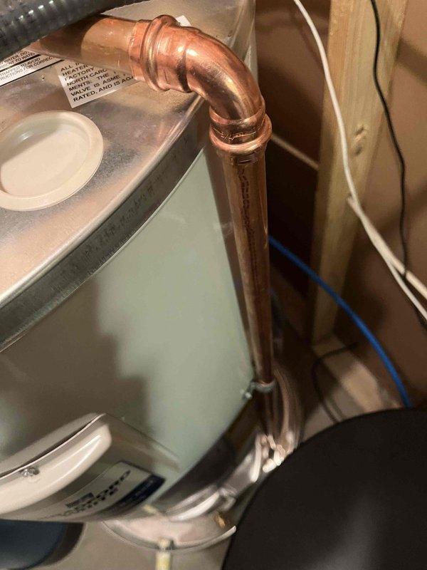 Installed correctly sized drain pan for water heater with adequate clearance between heater and pan edge. Connected temperature and pressure relief valve to drain properly into pan, and extended drain line from pan to existing floor drain as required per inspection correction.