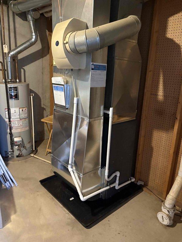 Successfully completed installation of new furnace unit in utility area, including proper connection of PVC ventilation pipes and ductwork components. System was fully tested and is operating at optimal efficiency with all mechanical connections secured and drainage properly configured.