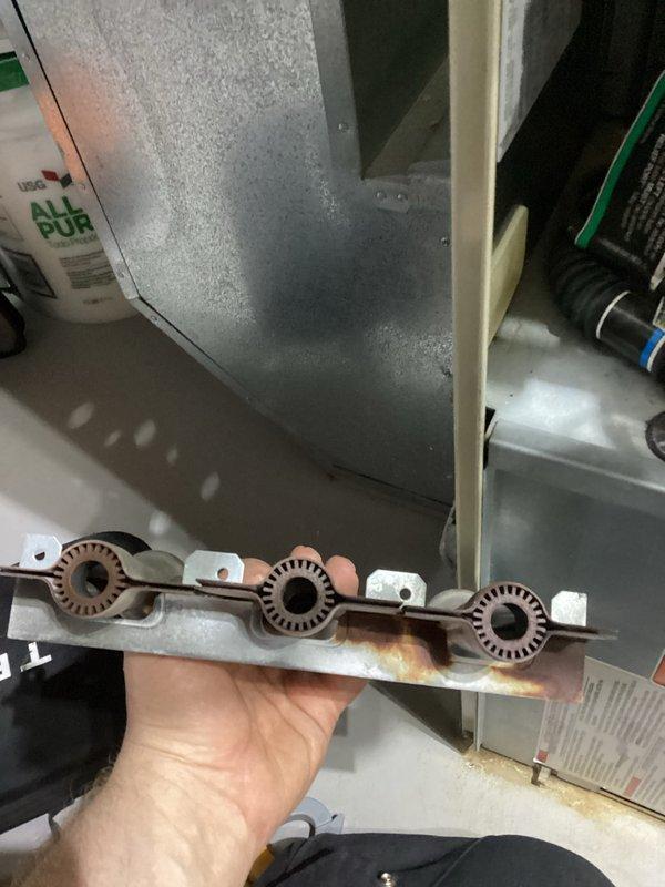 Performed annual heating tune-up on 24-year-old Carrier furnace. Removed and inspected burner assembly which showed signs of rust and wear. Checked internal components and wiring connections, noting serial number 315827-302, with particular attention to terminal connections of the red and green wires.