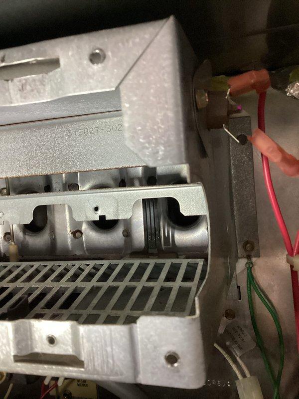 Performed annual heating tune-up on 24-year-old Carrier furnace. Removed and inspected burner assembly which showed signs of rust and wear. Checked internal components and wiring connections, noting serial number 315827-302, with particular attention to terminal connections of the red and green wires.