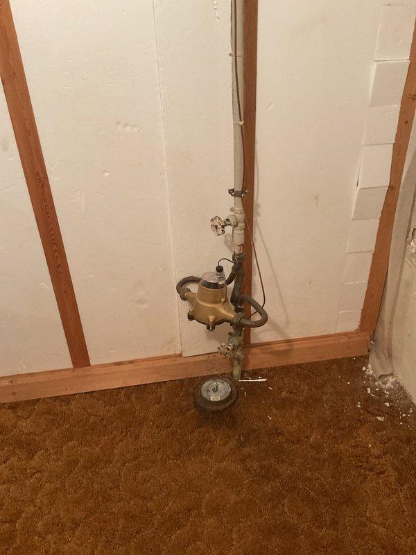 Responded to customer report of basement drain backup. Inspected plumbing system in partially finished basement area, focusing on the brass valve assembly and connected piping. Cleared blockage in drain line and verified proper drainage function before completing service.