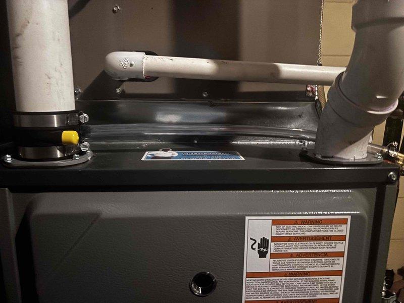 Performed annual heating service on a furnace system with no humidifier present. Inspected PVC venting connections and drain assembly for proper installation and condition. Examined furnace unit including safety components, gas valve, and warning systems. System is functioning properly with no issues identified.